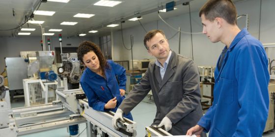 Foto de un formador en un taller enseñando a dos estudiantes