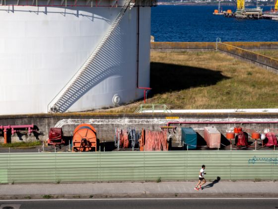 Imagen de joven corriendo en dirección contraria a una zona industrial