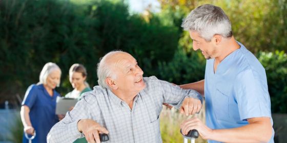 Hombre cuidando de un anciano con muletas