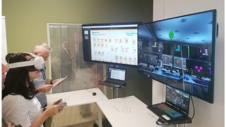 Mujer con gafas de realidad virtual con mandos frente a dos pantallas