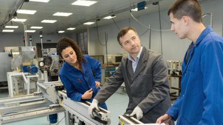 Foto de un formador en un taller enseñando a dos estudiantes