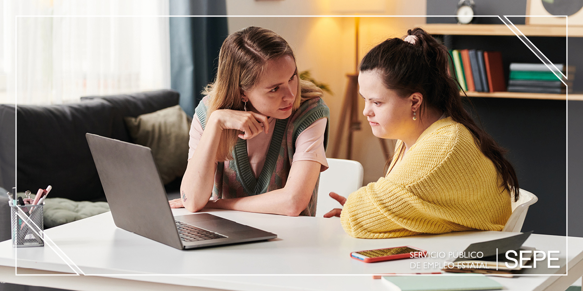 Imagen de mujer impartiendo formacion a una joven con discapacidad