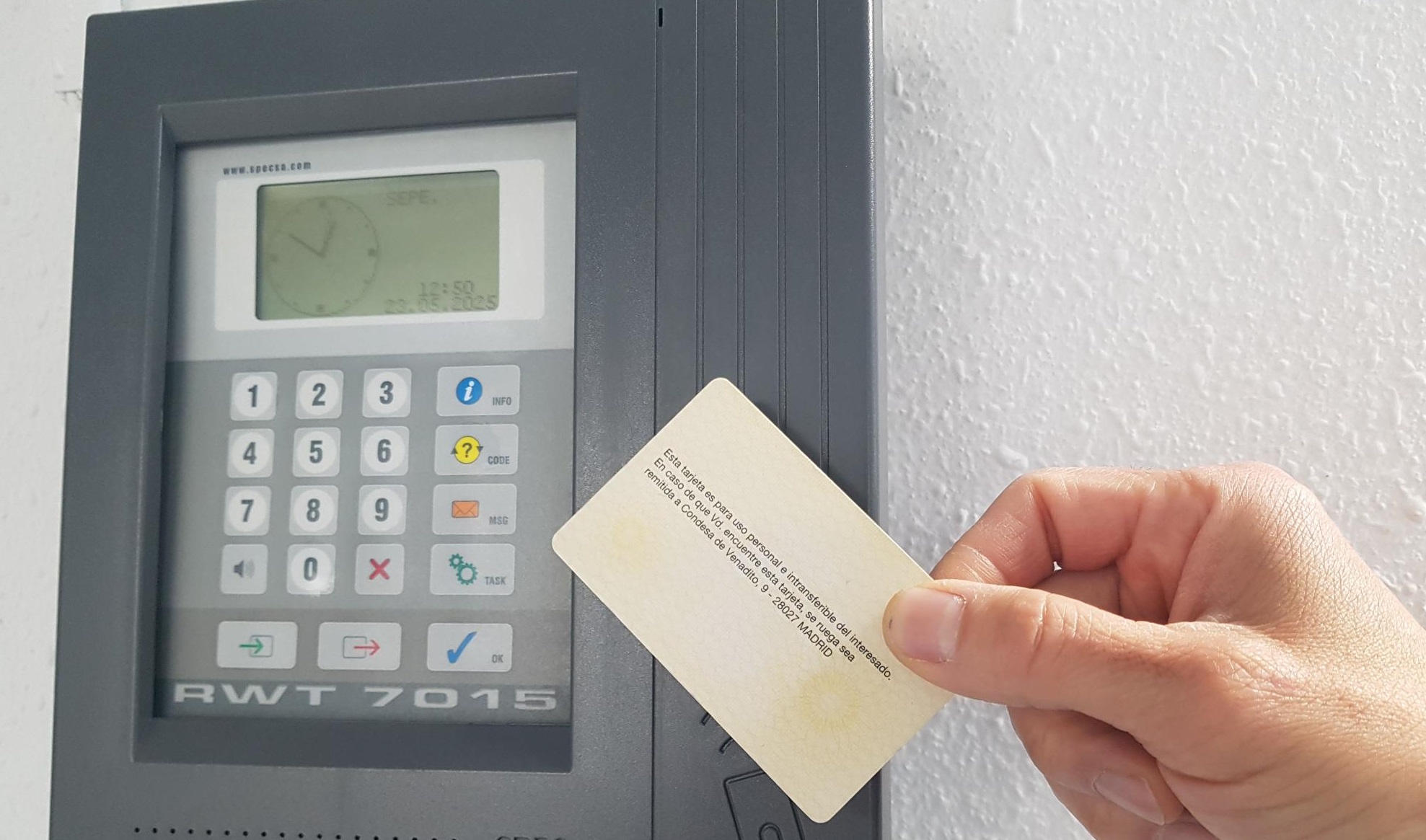Imagen de una mano aproximando una tarjeta a una máquina de fichaje