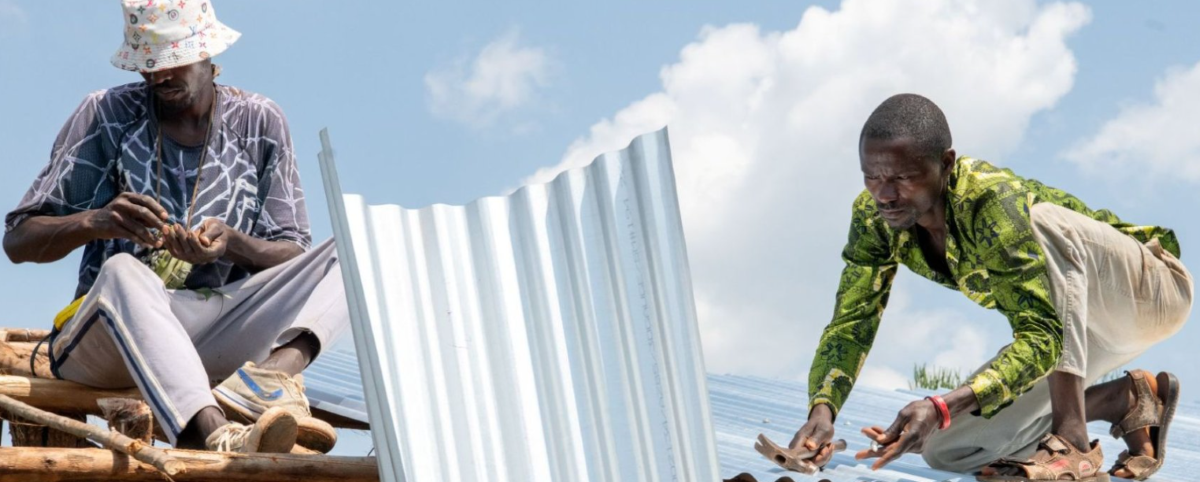 Dos trabajadores sobre un un tejado instalando planchas metálicas con el cielo de fondo.