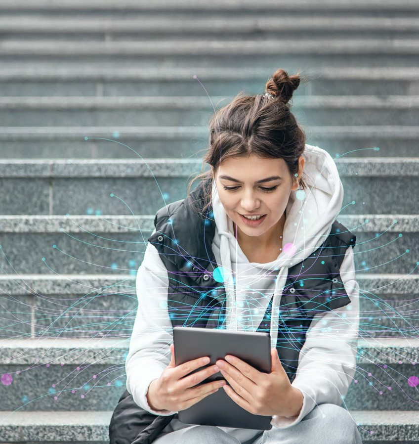 Imagen de una chica sentada en unas escaleras de la calle, mirando una tablet de la que salen unas pequeñas esferas unidas por figuras gráficas